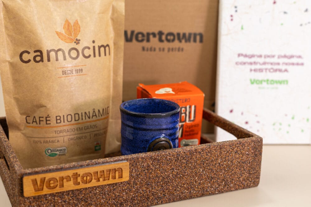 kit de presente sustentável com: bandeja de café, moleskine, copinho, café e doce em cubos. Imagem com aproximação dos elementos.