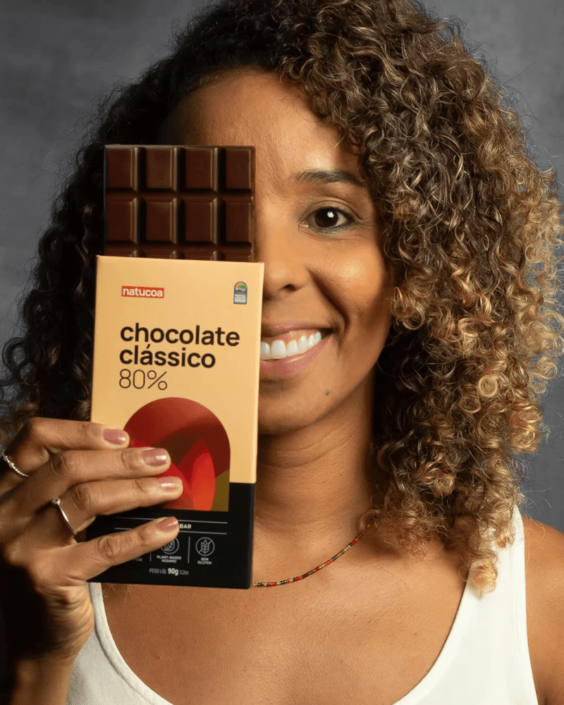 Carine segurando chocolate da Natucoa