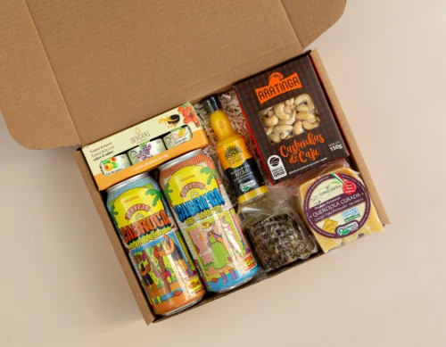 kit de presente sustentável com: cervejas, castanha, socol, molho pequi com pimenta, queijo, trio geleias. kit de presente sustentável com: cervejas, castanha, socol, molho pequi com pimenta, queijo, trio geleias. Imagem com aproximação dos elementos.