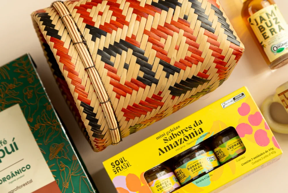 kit de presente sustentável com: café Apuí, trio de geleias, mini cachaça jambu, copinho marajoara e cestaria baniwa. Imagem com aproximação dos elementos.