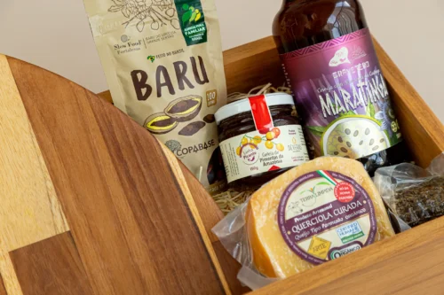 kit de presente sustentável com: tábua, castanha de baru, queijo, socol, cerveja maratinga e geleia de pimenta. Imagem em aproximação dos elementos.