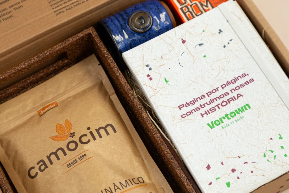 kit de presente sustentável com: bandeja de café, moleskine, copinho, café e doce em cubos. Imagem com aproximação dos elementos.